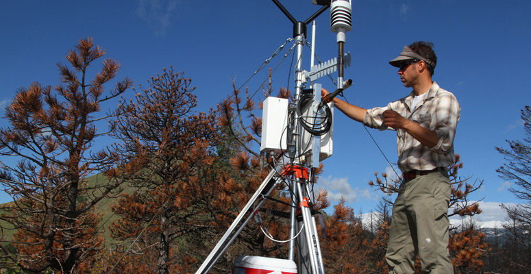 An NCAR scientist with a weather monitoring station