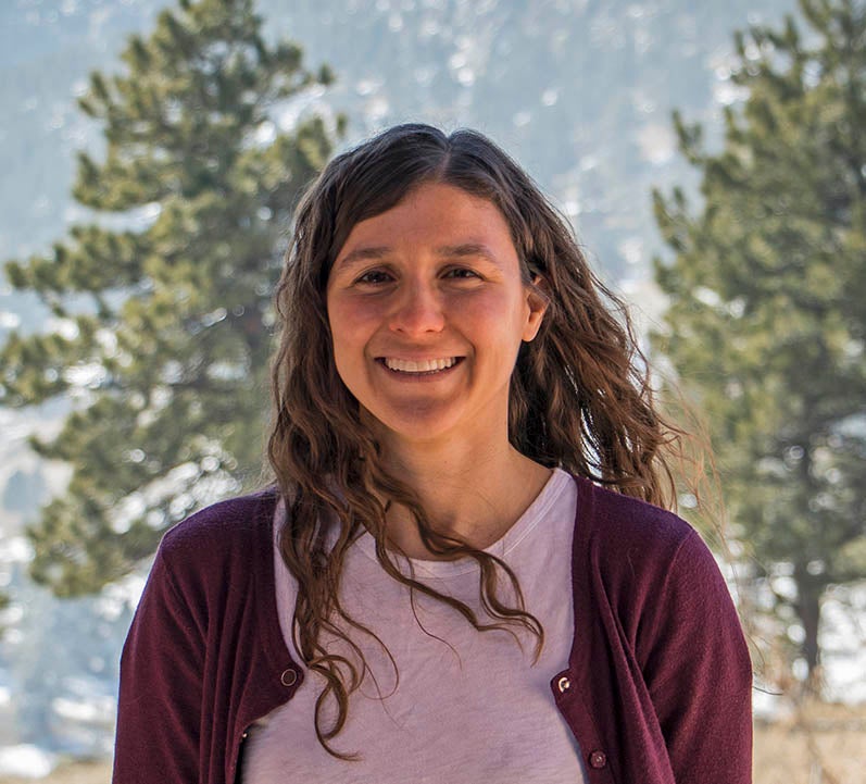 Photo of Danica Lombardozzi with trees and mountains in the background. 