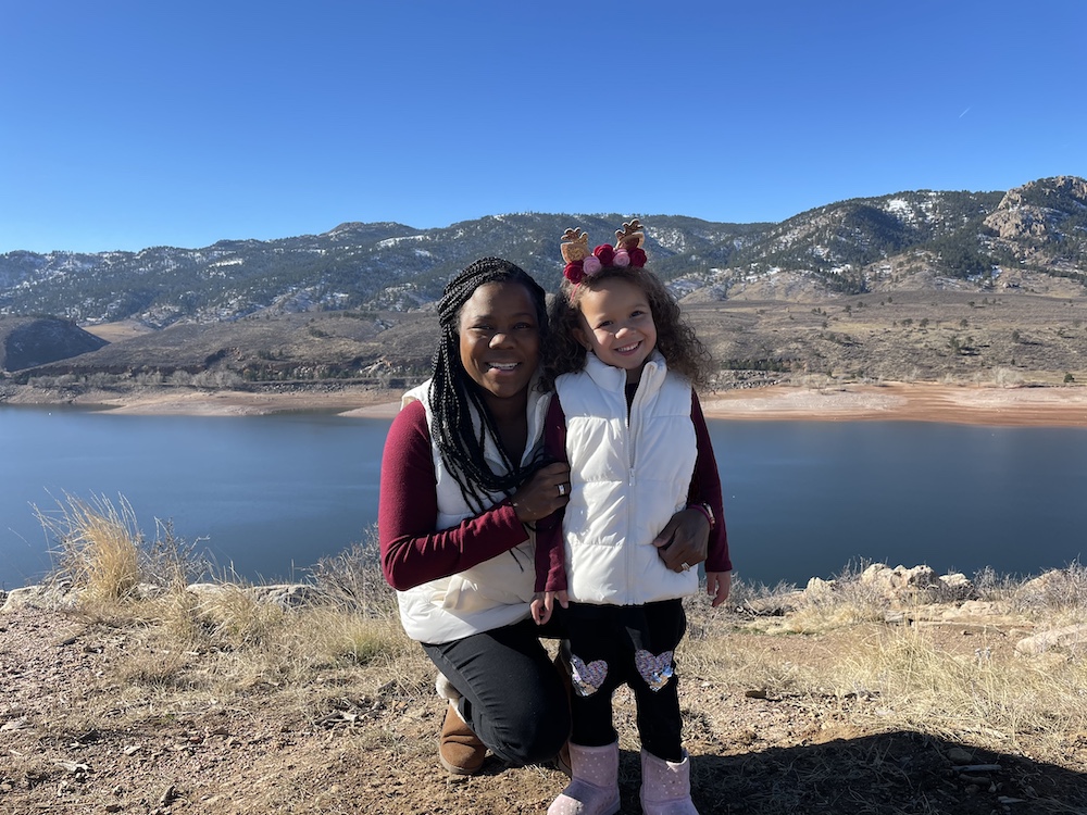 Dr. Melissa Burt with her daughter in front of a mountain lake