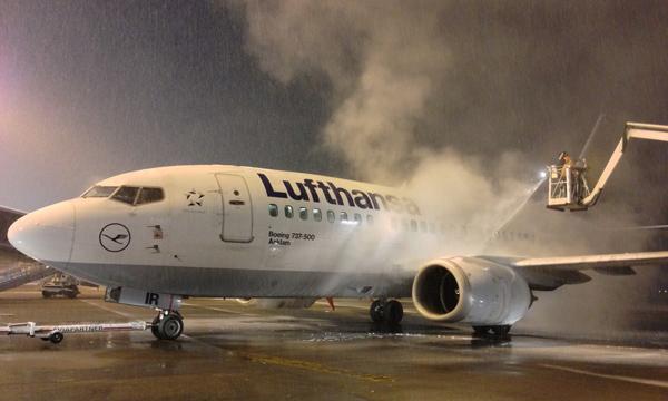 A jet getting deiced on the runway